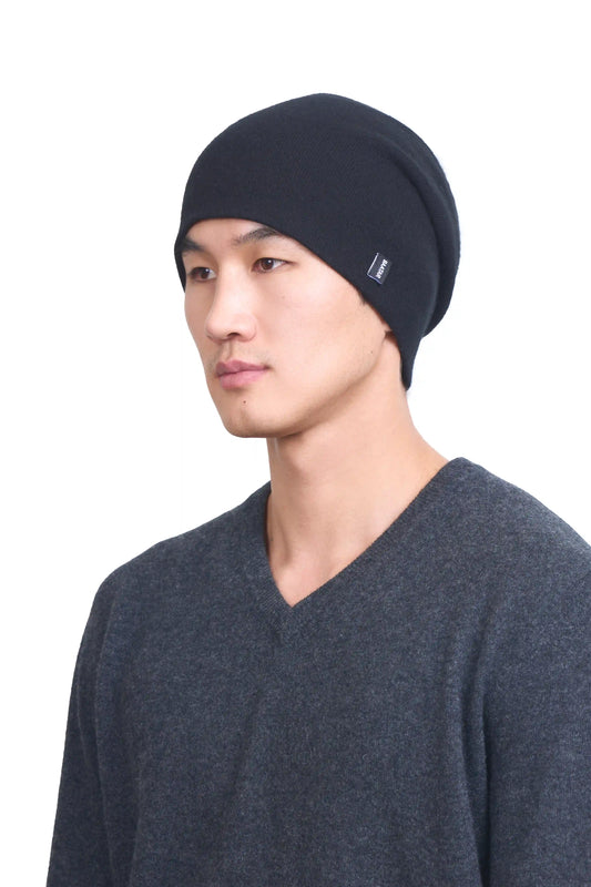 Mongolian male model in 3/4 view wearing a soft black cashmere beanie, highlighting the luxurious texture and elegant design against a neutral background